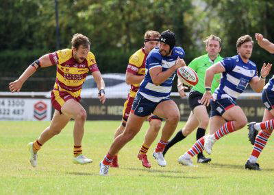 Players chase the ball carrier during Sedgley Park against Sheffield at Park Lane