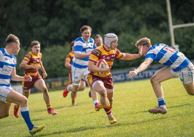 A Sedgley Park Tigers ball carrier hands off a Tynedale defender and breaks through the line