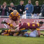 A Sedgley Park Tigers player grounds the ball for a try as teammates and the Park Lane crowd celebrate