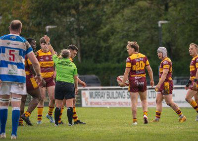 The referee signals a penalty as Sedgley Park and Tynedale players look on at Park Lane