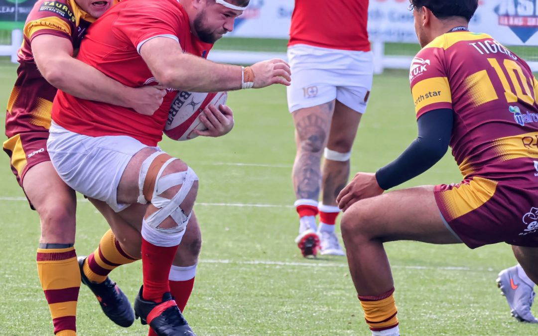 A Chester ball carrier is held up by the Sedgley Park defence at Hare Lane