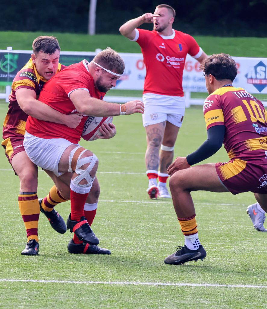A Chester ball carrier is held up by the Sedgley Park defence at Hare Lane