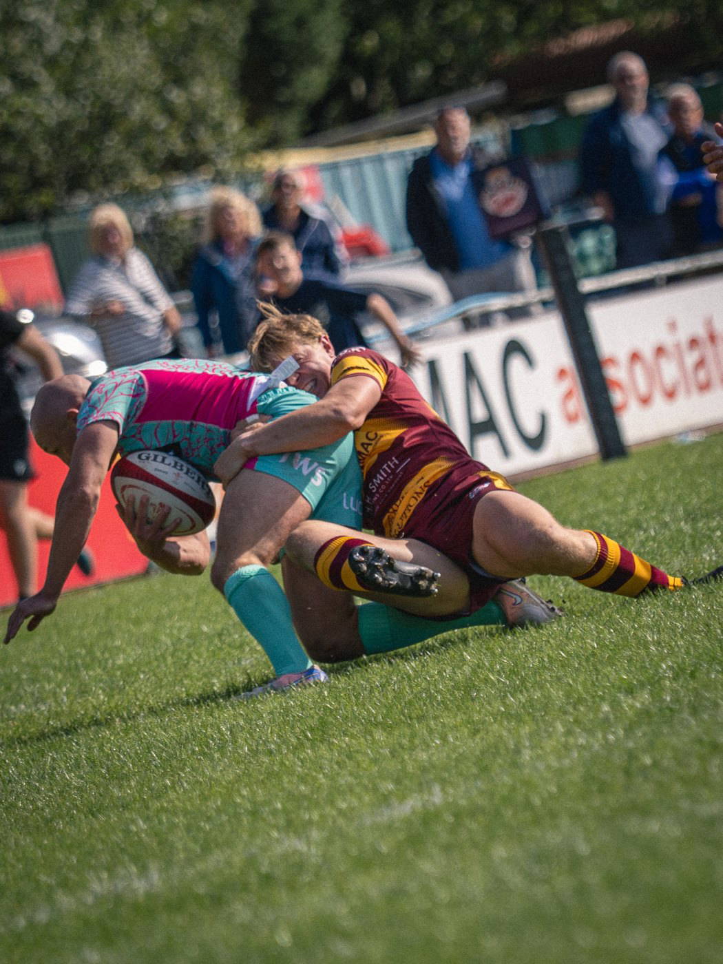 A Sedgley Park player completing a tackle in front of the advertising boards at Park Lane
